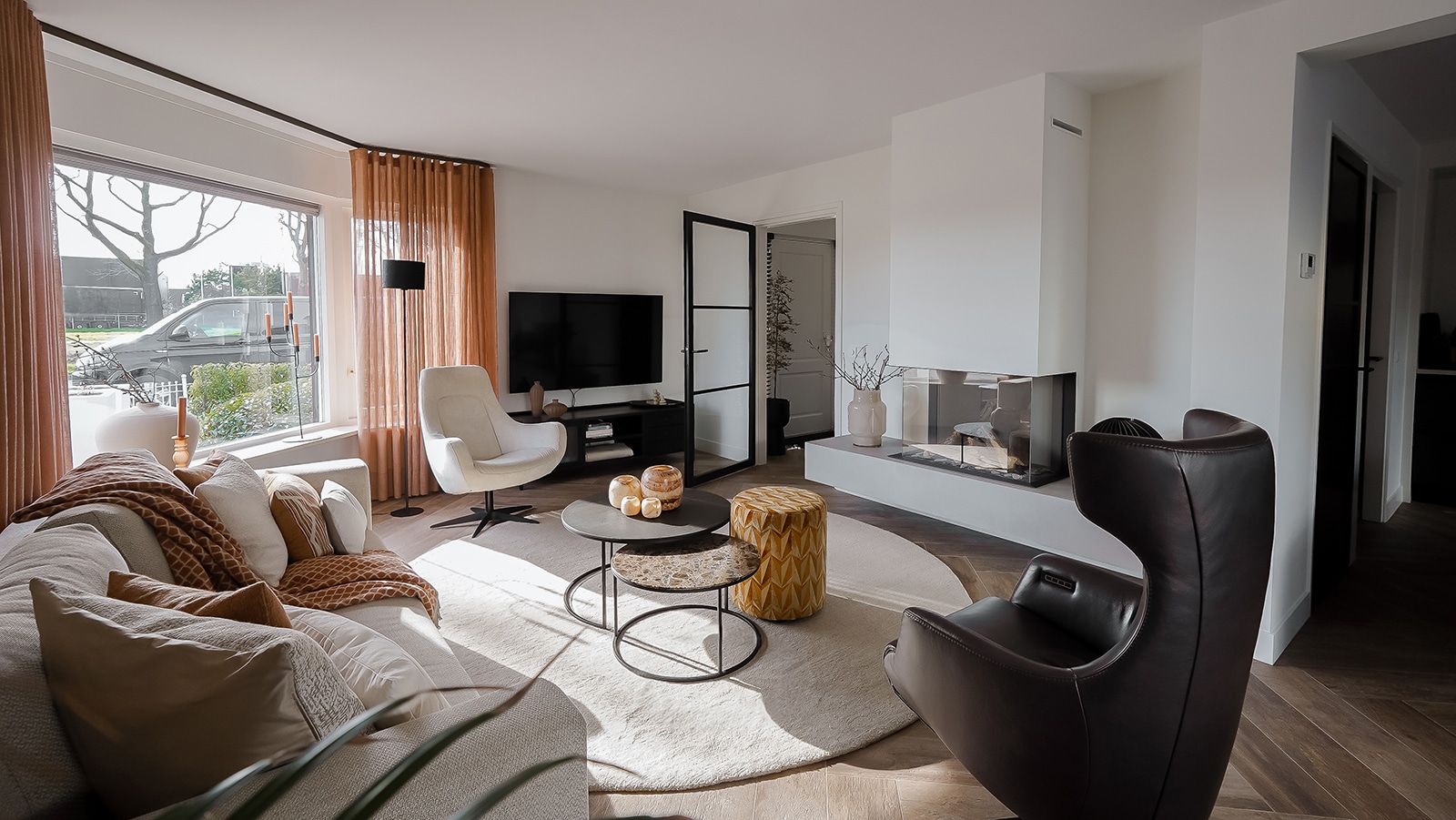 Sfeervolle woonkamer met bank, fauetuil, bijzettafels en vloerkleed